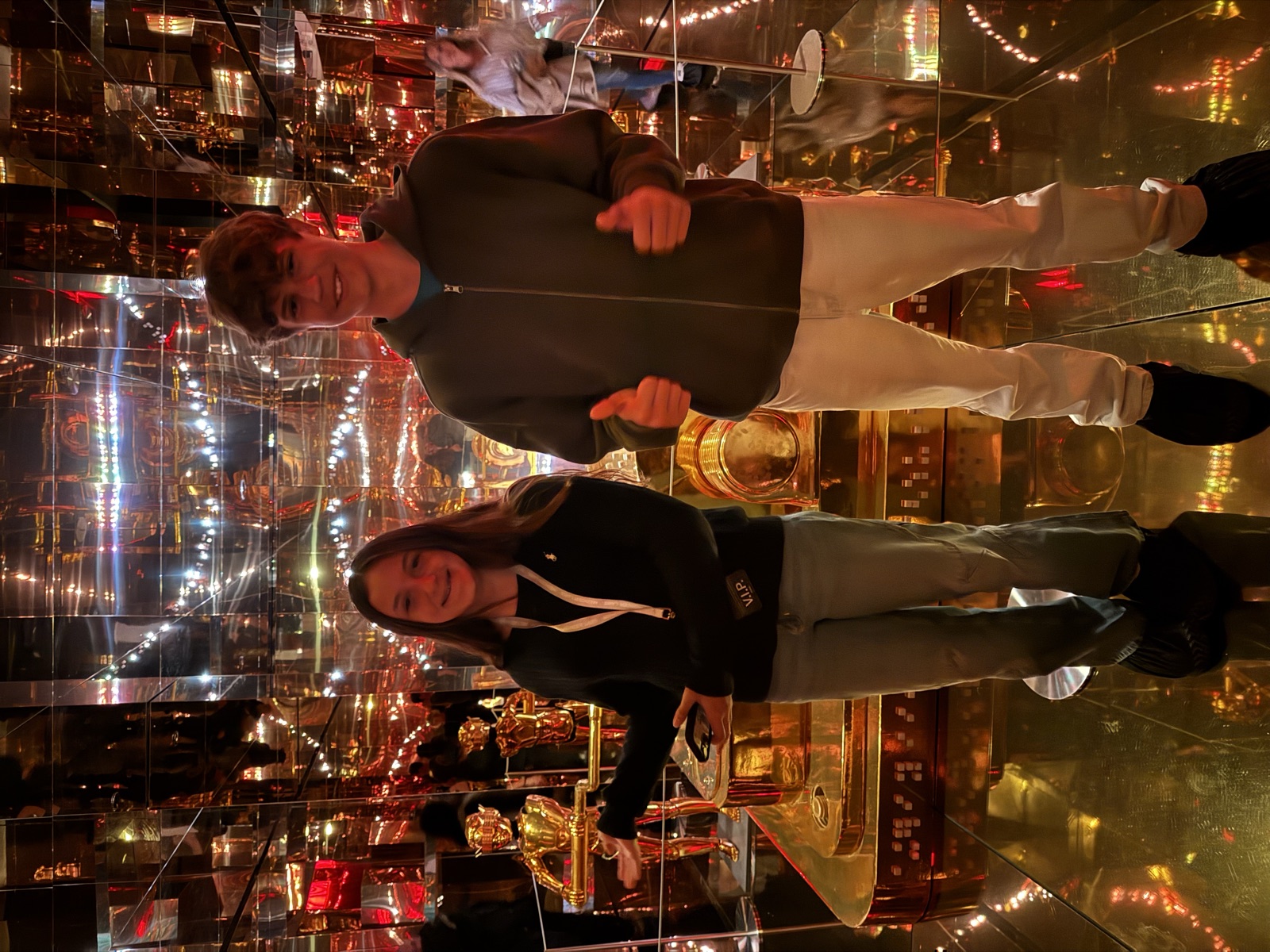 Ruby in a mirrored room of gold statues and lights