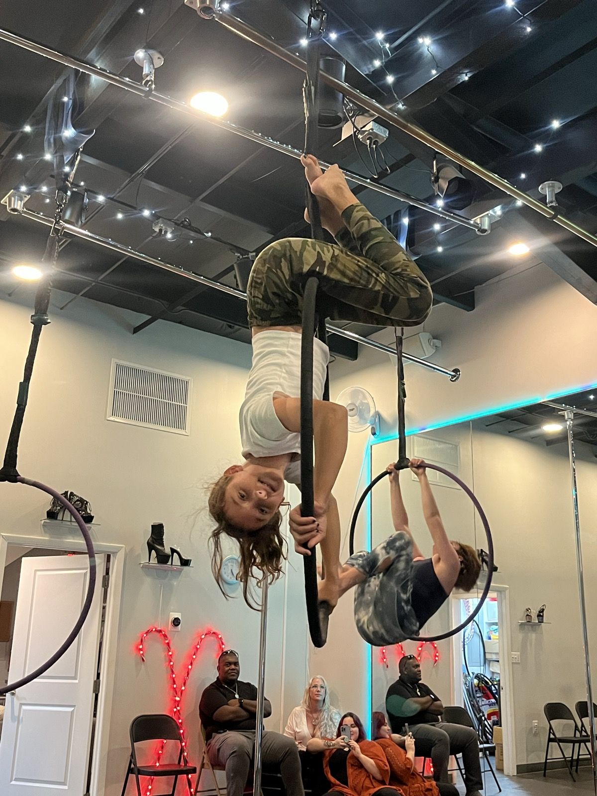 Ruby upside down on an aerial hoop in class