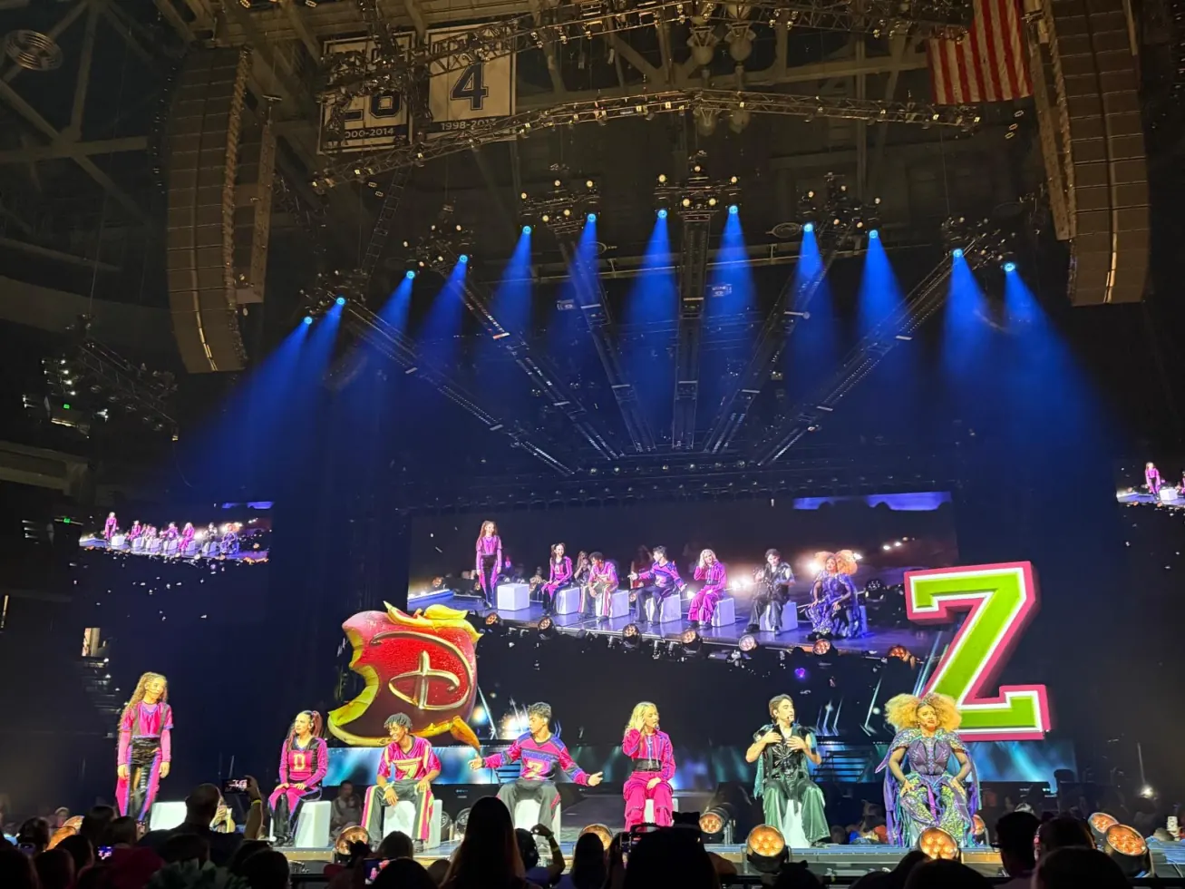 The full stage with the cast lined up under blue lights and a giant letter Z