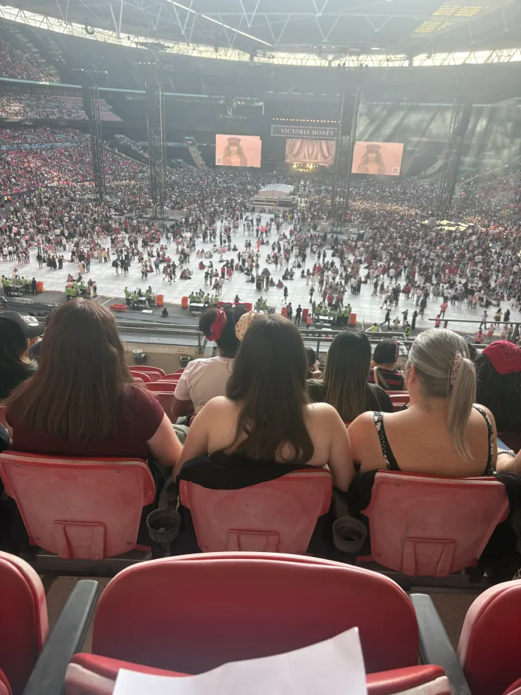The stadium floor and screens seen from high in the red seats