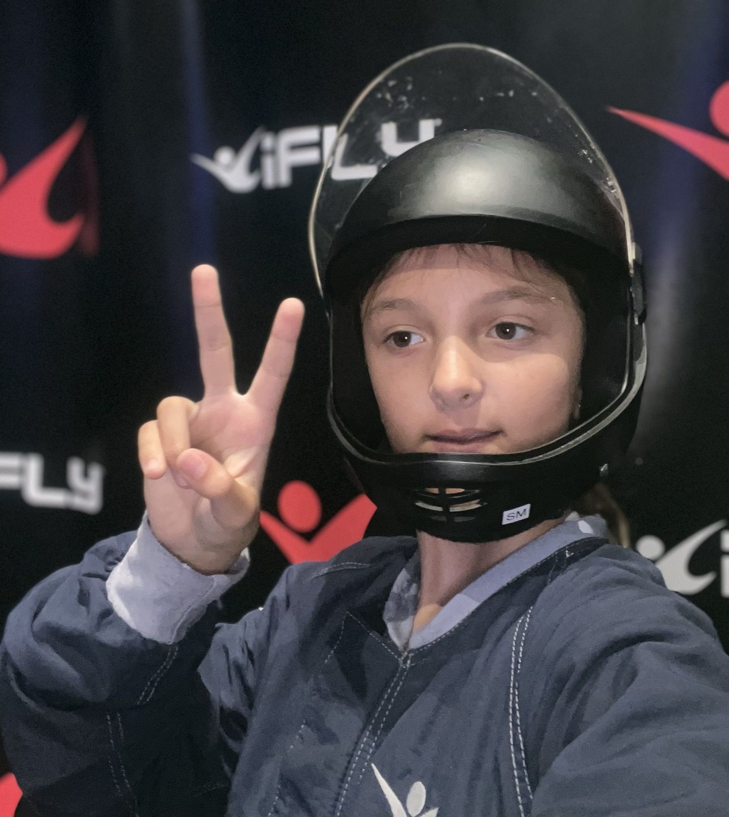 Ruby in an iFLY helmet giving a peace sign