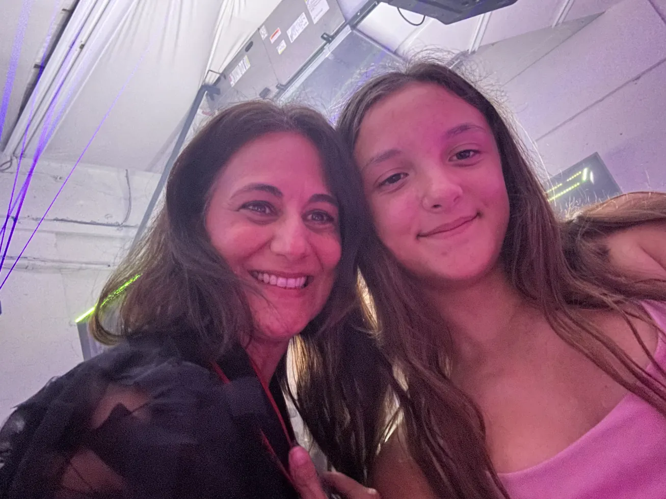 Ruby and her mom smiling together under party lights