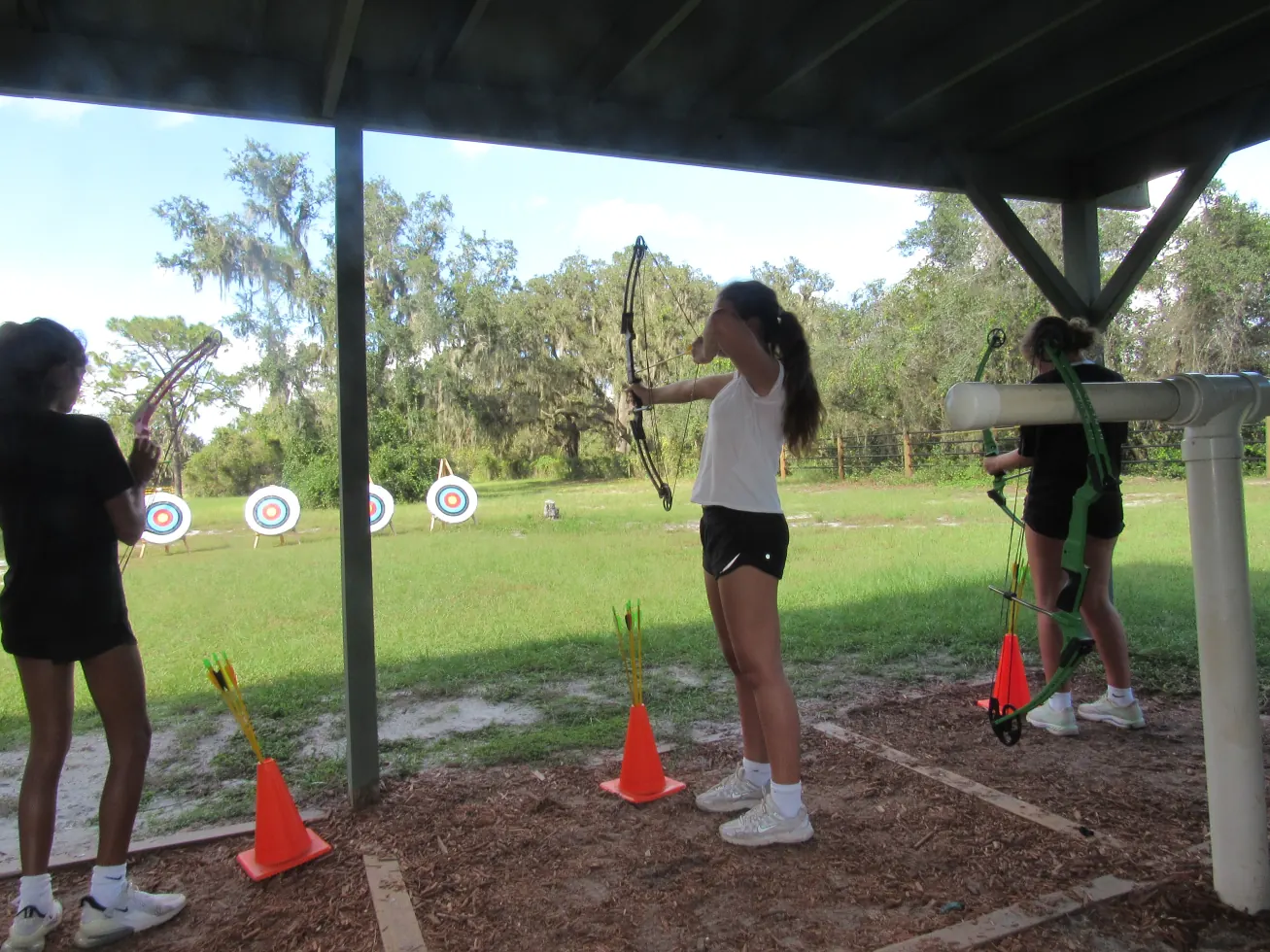 Ruby at full draw on the archery range