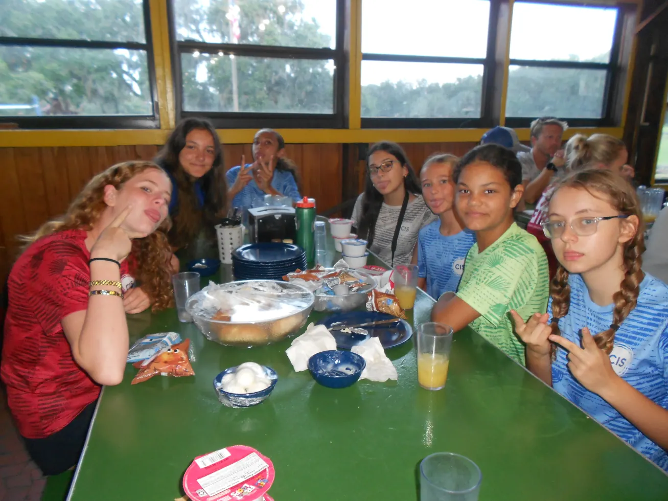 A cabin table of campers pulling faces over breakfast
