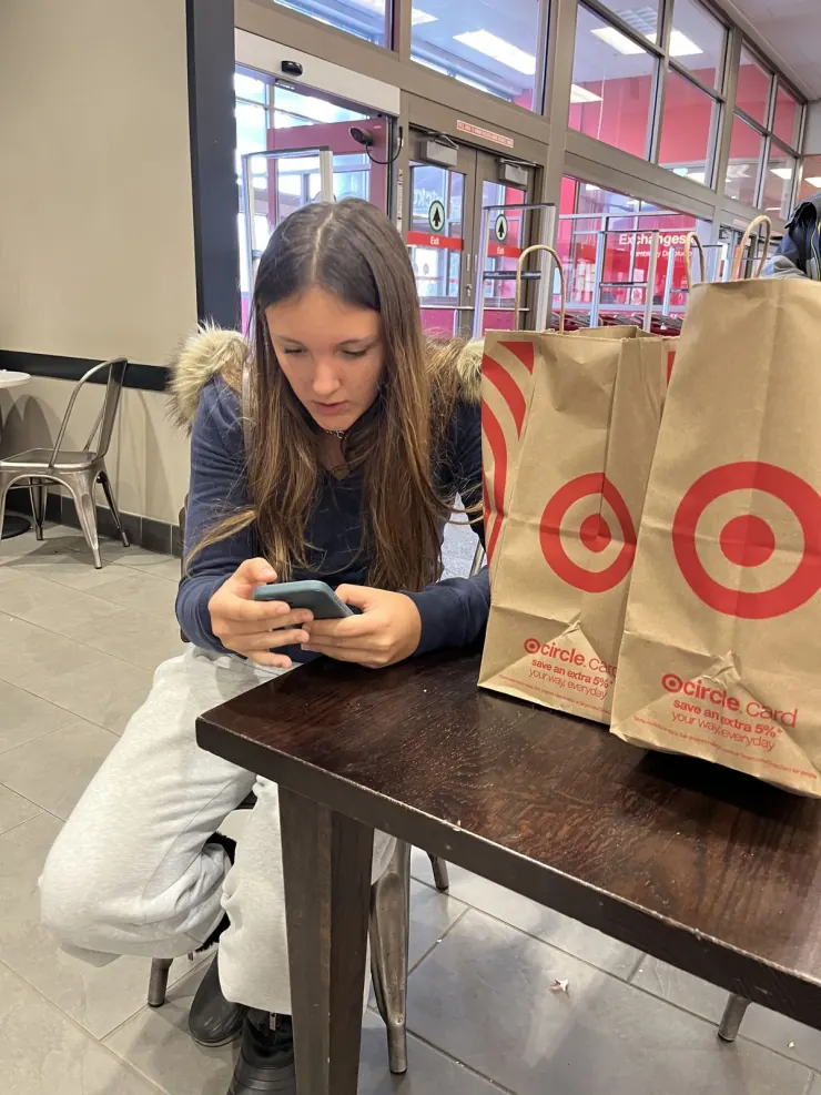 Ruby at a table with Target shopping bags