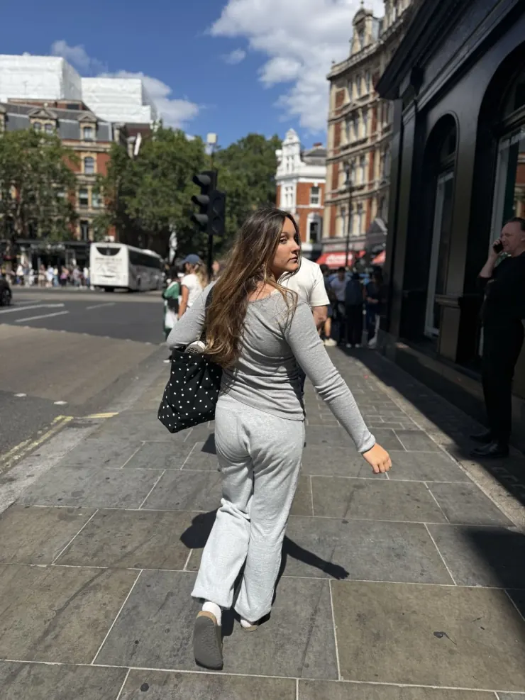 Ruby walking a London street in a gray knit set