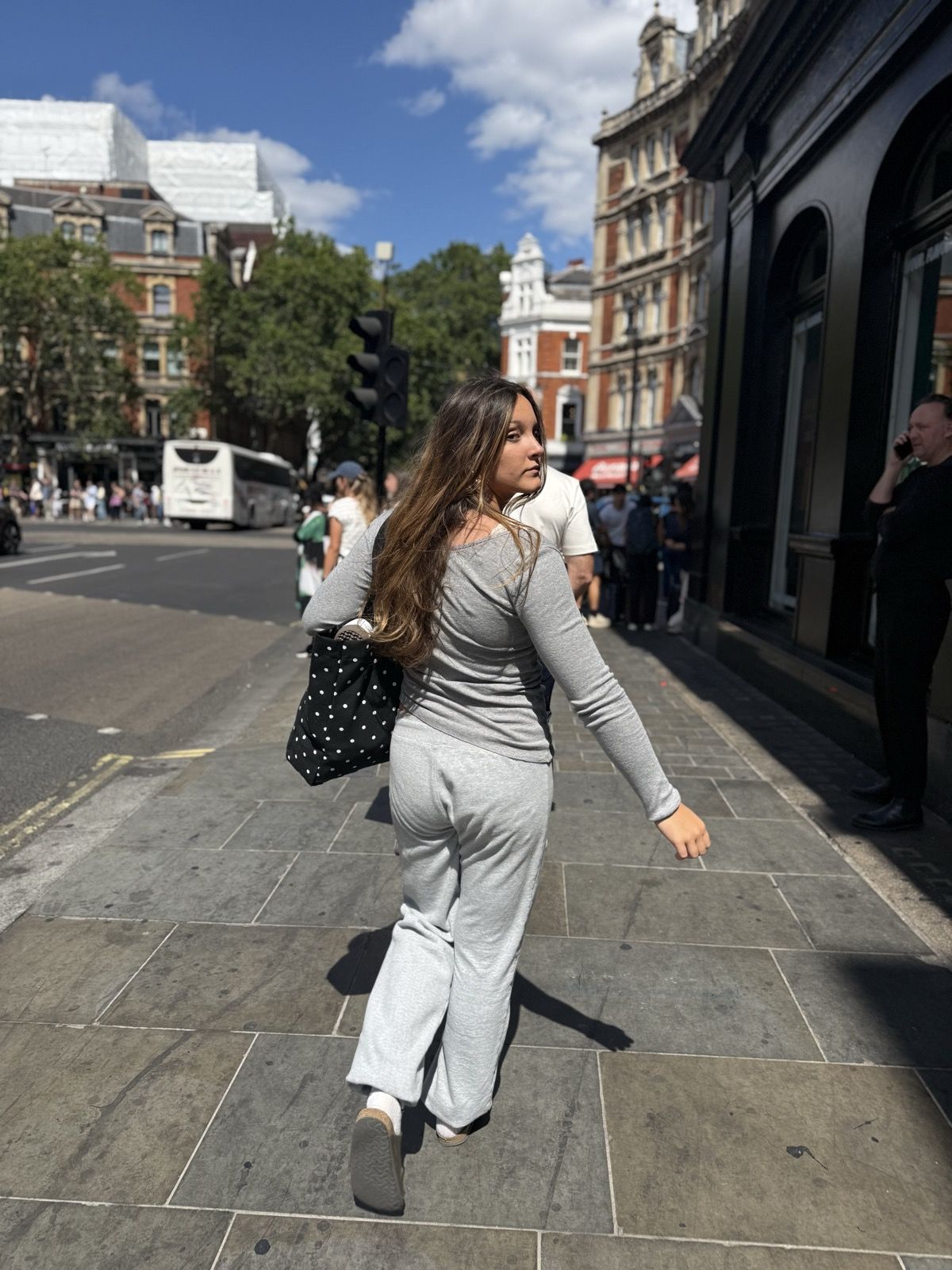 Ruby walking a London street in a gray knit set
