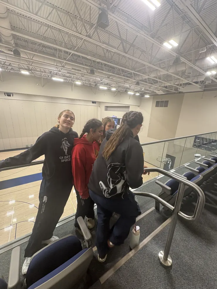 Ruby and teammates heading up to the stands above a gym court