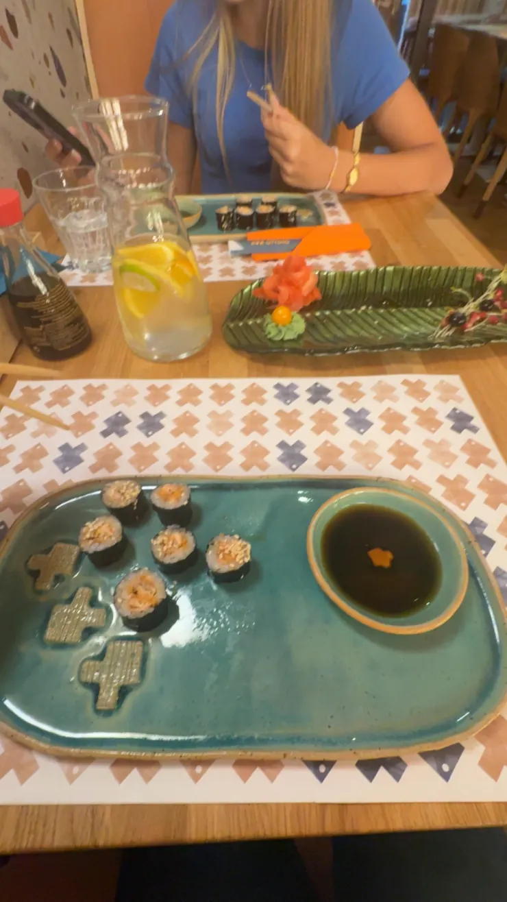 A friend across the table at a sushi restaurant