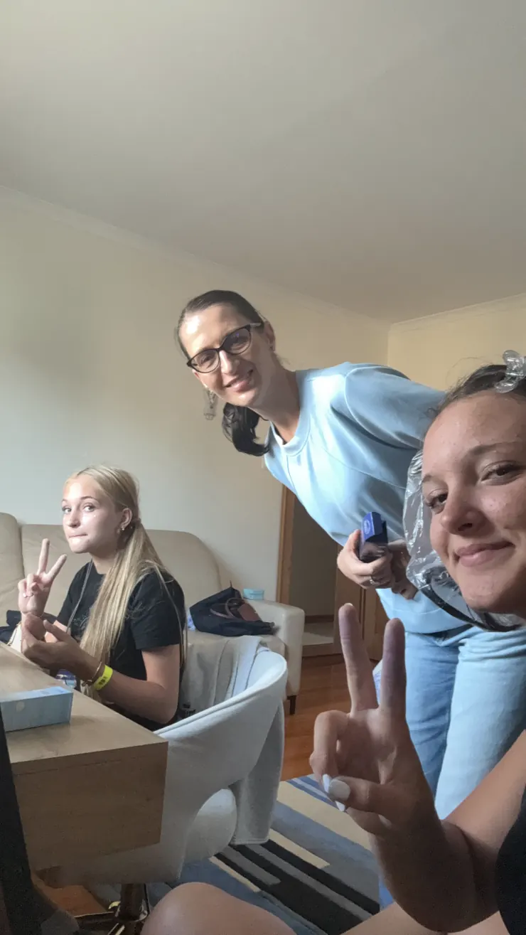 Ruby and family giving peace signs in a living room