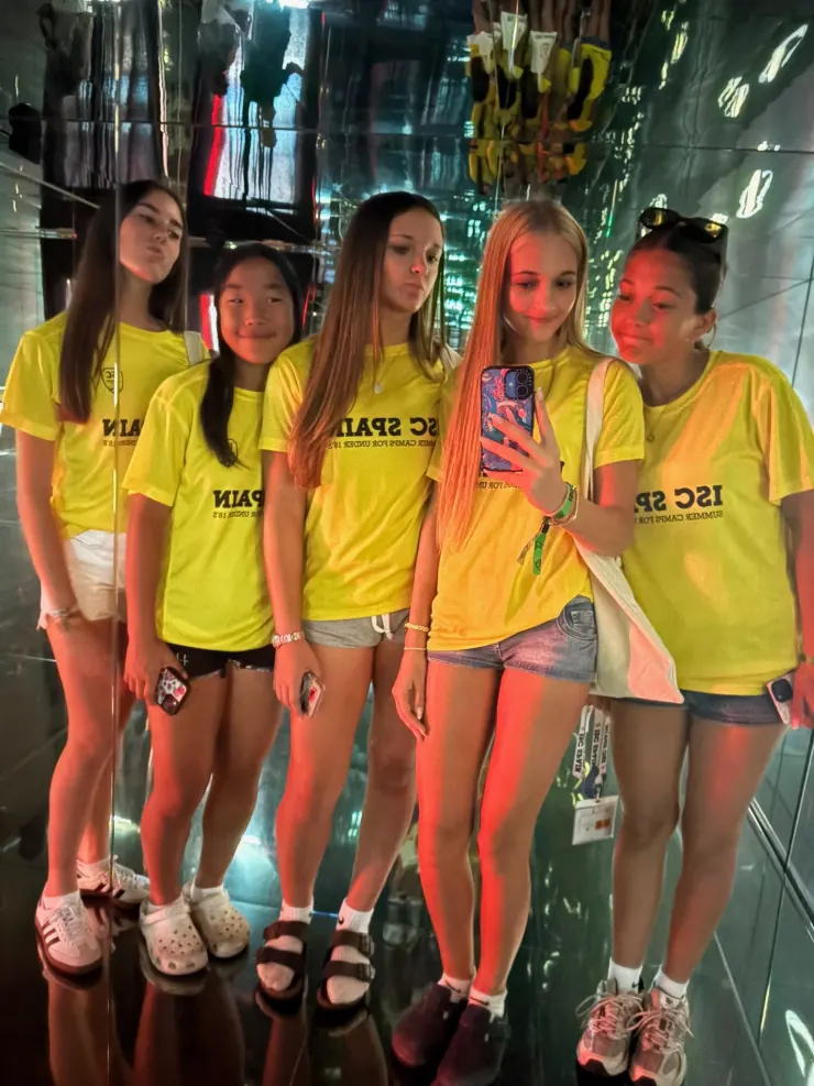 Ruby and camp friends in matching yellow ISC Spain shirts, mirror selfie